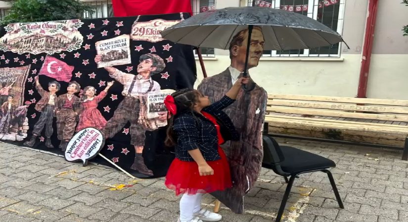 Yağmurda Atatürk maketini şemsiyeyle korudu